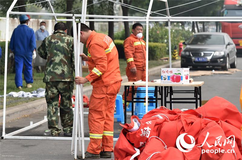 前方指挥中心附近停留的消防车辆及官兵均在向外撤离。人民网记者翁奇羽 摄