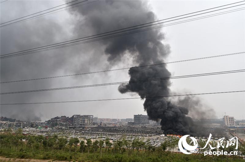 天津爆炸区今中午又有较大明火燃起伴有爆炸。人民网记者翁奇羽 摄