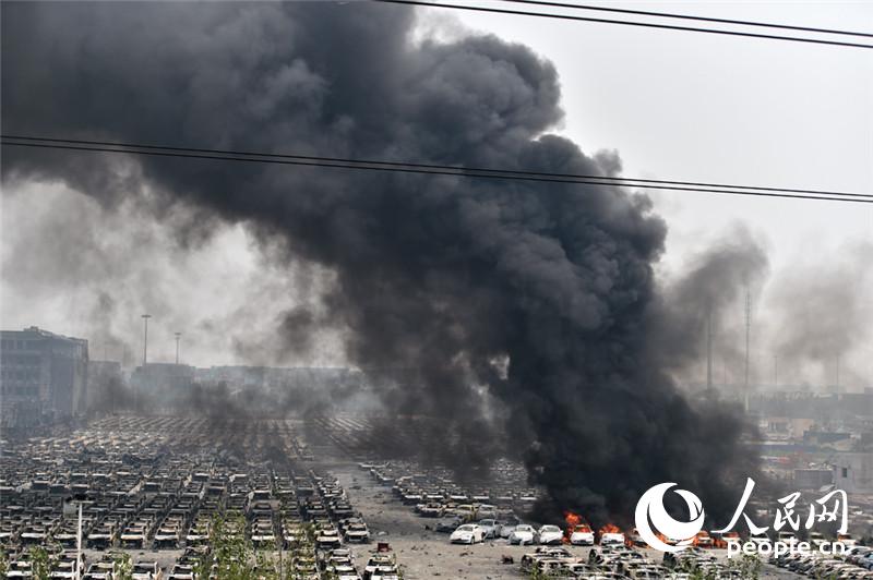 天津爆炸区今中午又有较大明火燃起伴有爆炸。人民网记者翁奇羽 摄