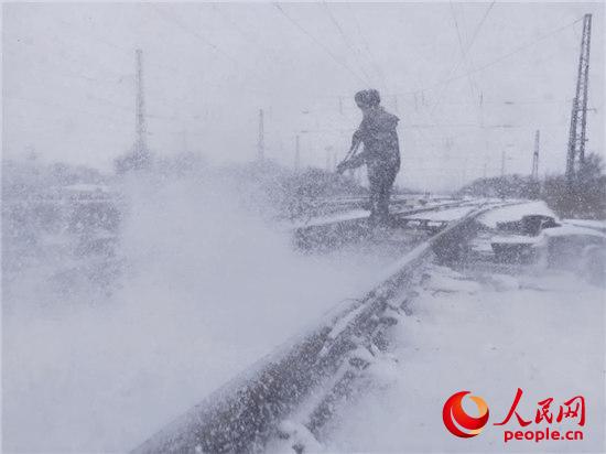 中国铁路沈阳局职工浴“雪”奋战畅通春运路