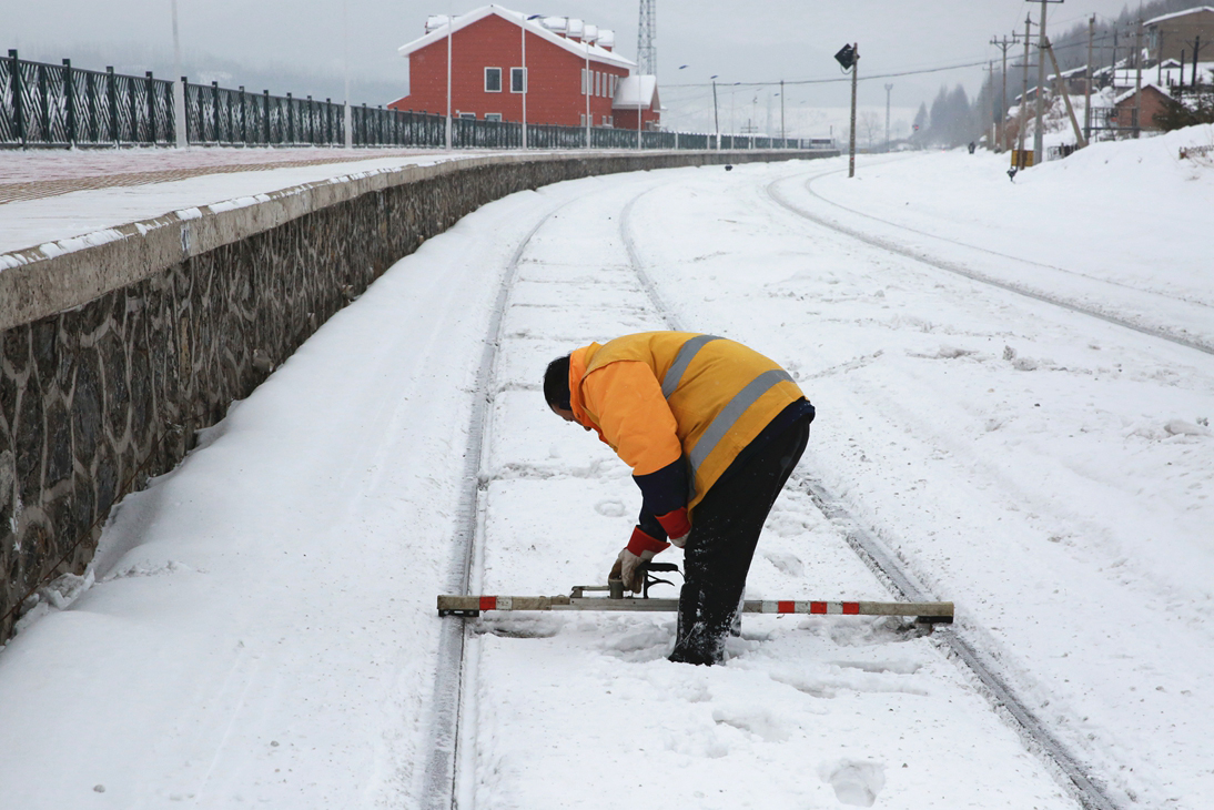 通化工务段松树镇线路车间职工每测量一处数据，就要将轨面积雪清除。（关贺贺摄）