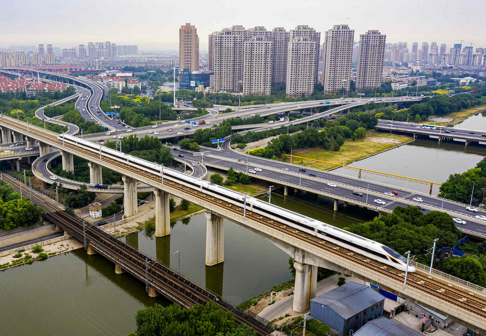 6月30日，一列由北京南开往天津的京津城际复兴号动车组列车在天津市区铁路线上行驶。 杨宝森/摄