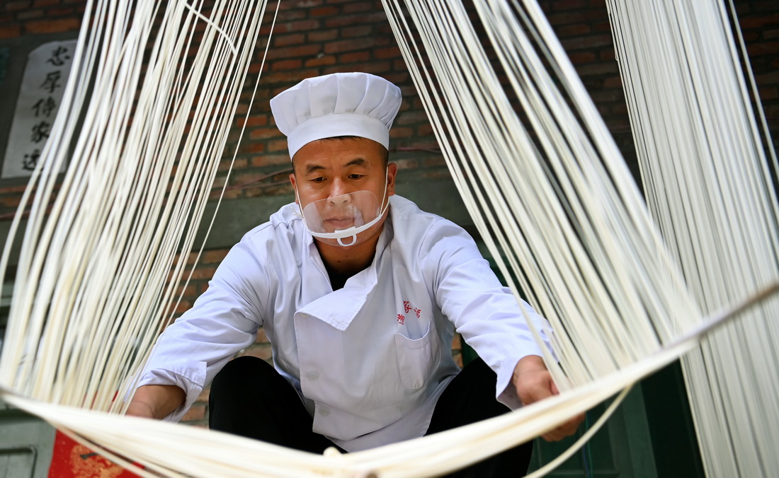 8月16日,李长满的儿子李念平在晾晒空心挂面。从小帮助父亲制作挂面的李念平,耳濡目染中掌握了制作空心挂面的技艺。