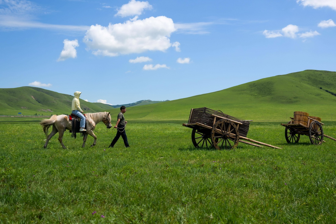 7月25日，一名游客在吴苏道（右）的带领下体验骑马。新华社记者 李志鹏 摄