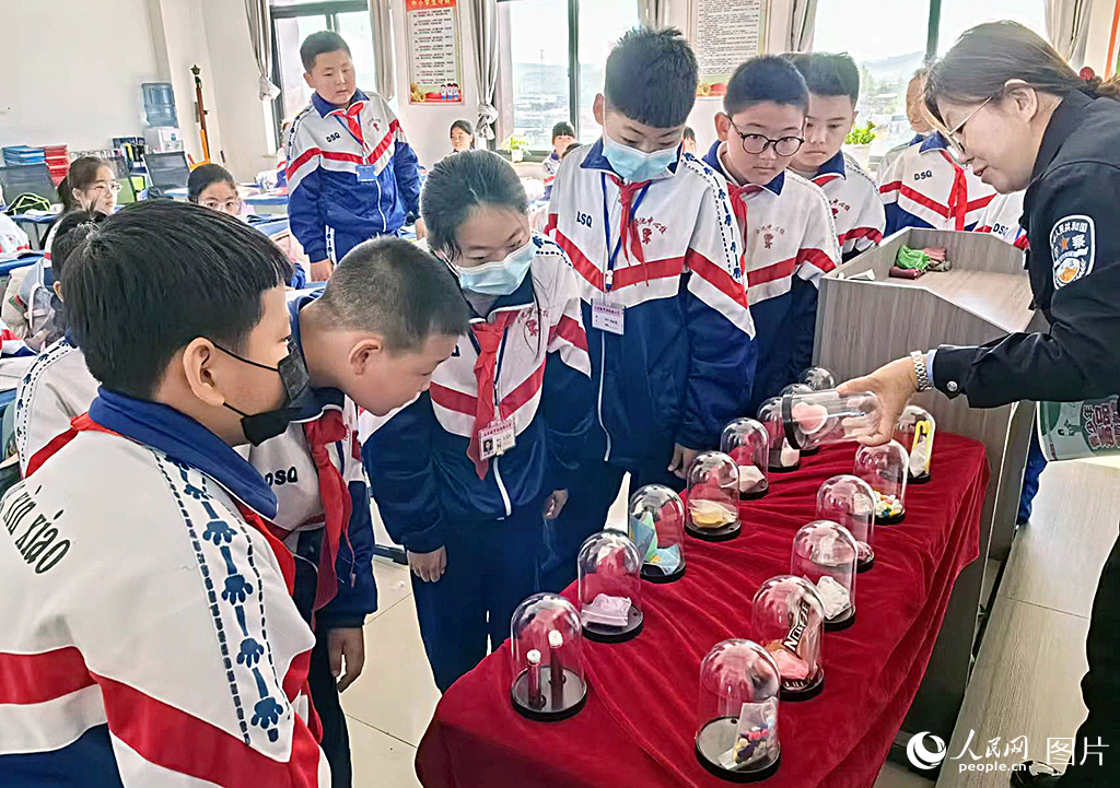 宣传民警向师生讲解禁毒、反诈、反恐、防溺水、交通安全知识。