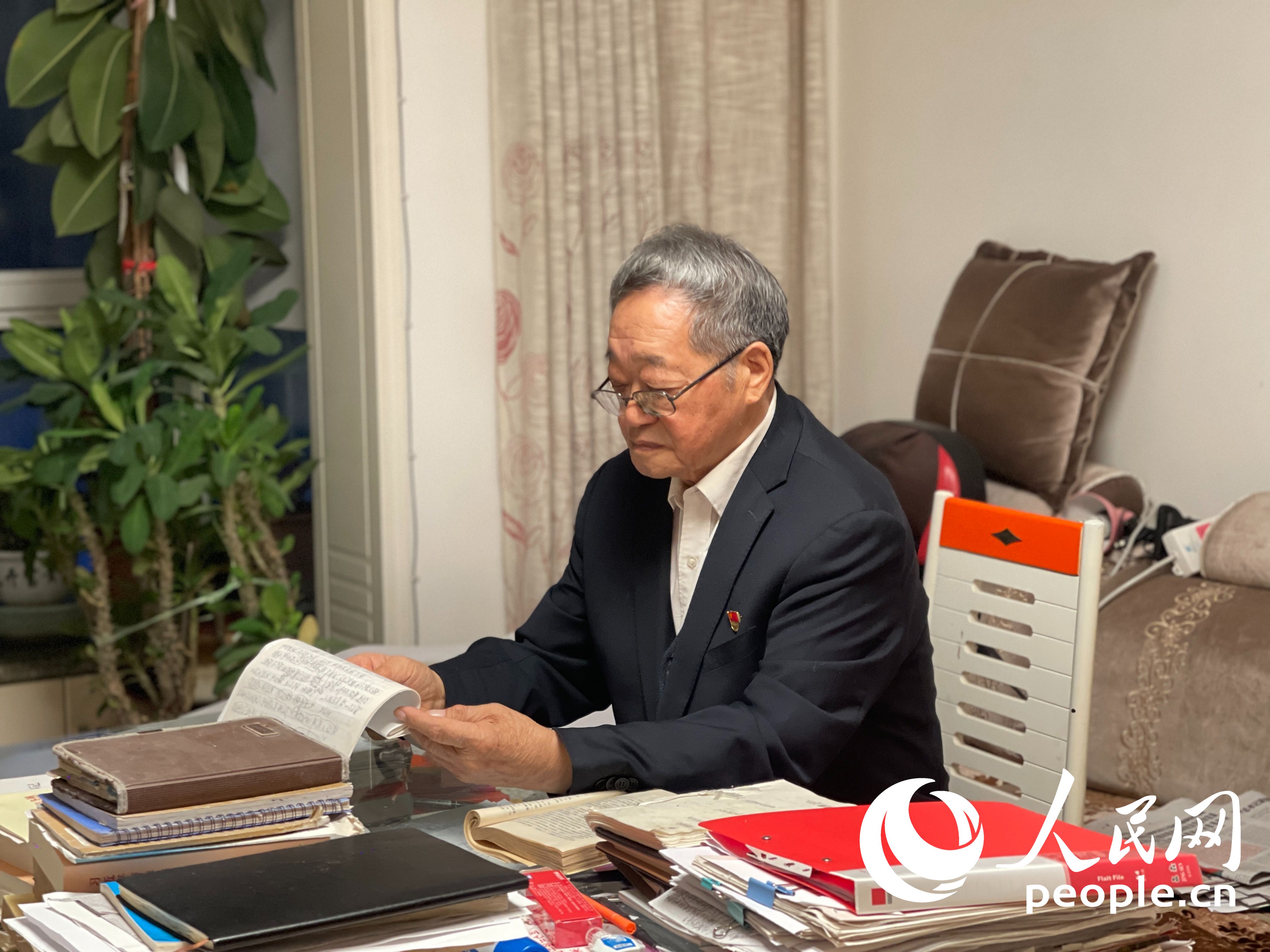  Xu Jinshi is reading the propaganda materials. Photographed by Zhou Jingyuan on People's Daily Online