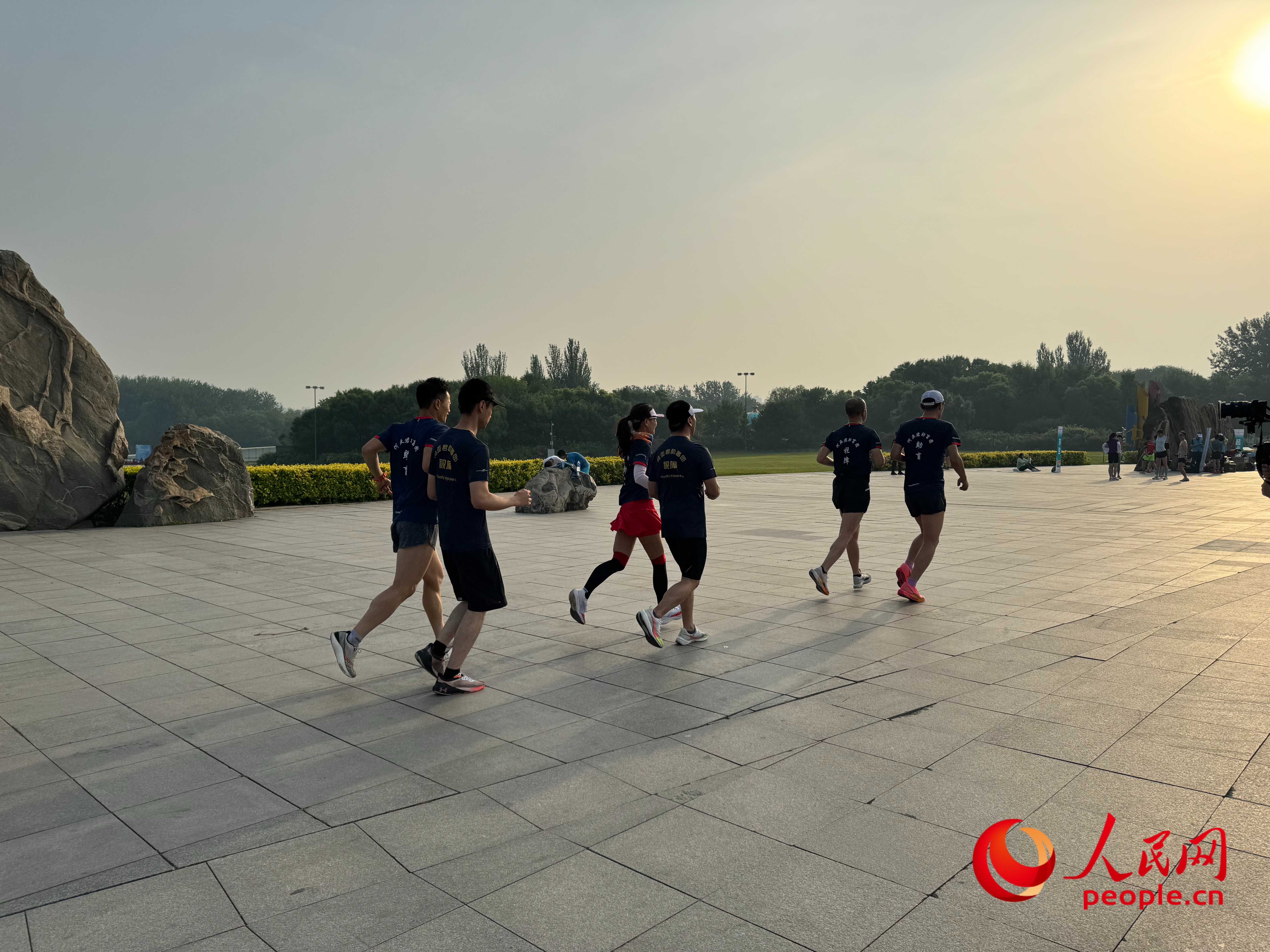 北京オリンピック森林公園では、視覚障害者のランナー団が朝日を浴びて走っている。人民網周静円撮影