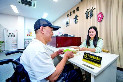 浙江杭州河庄体裁中心藏书楼责任主谈主员在为残疾东谈主提供册本借阅服务。新华社发