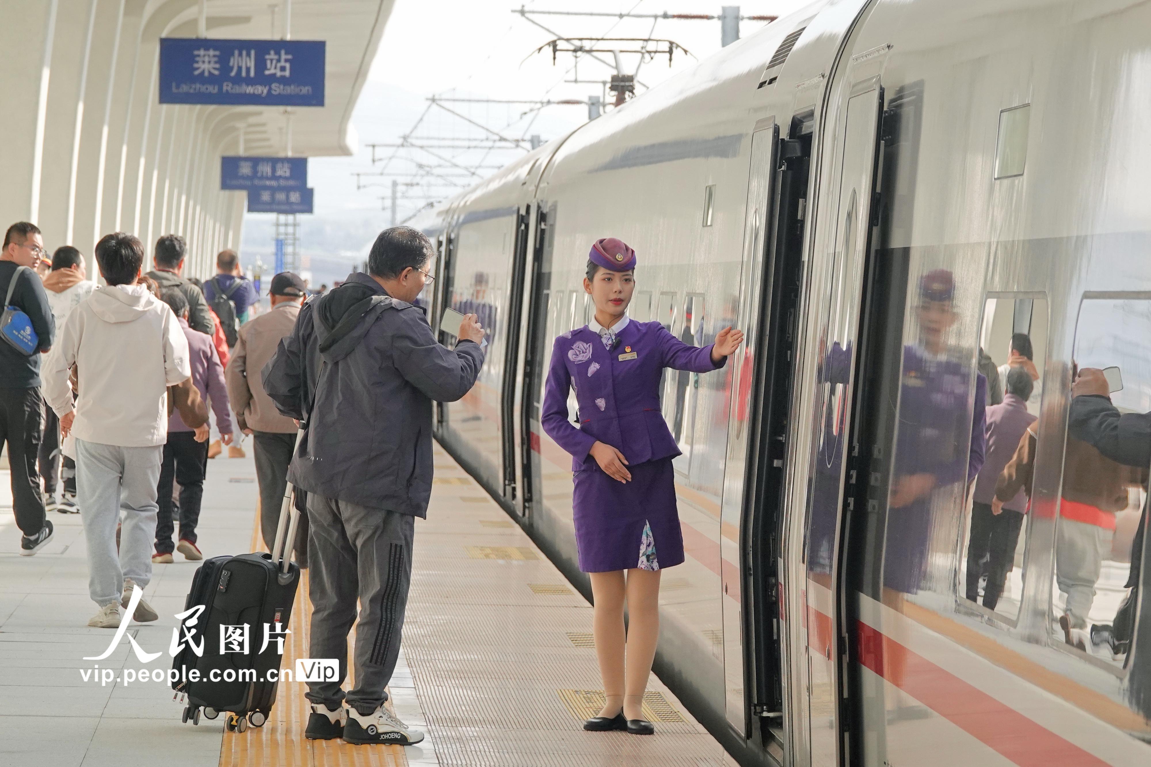 2024年10月21日，在山东莱州站，旅客乘坐潍烟高铁首发列车出行。