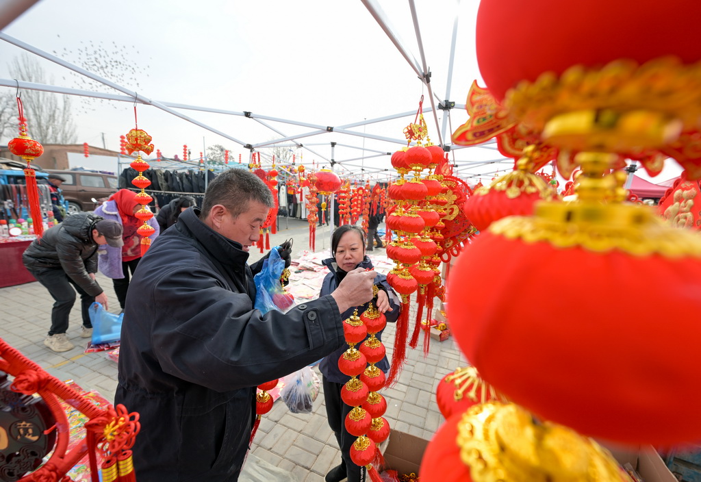 1月21日，人们在金贵集贸市场选购春节饰品。