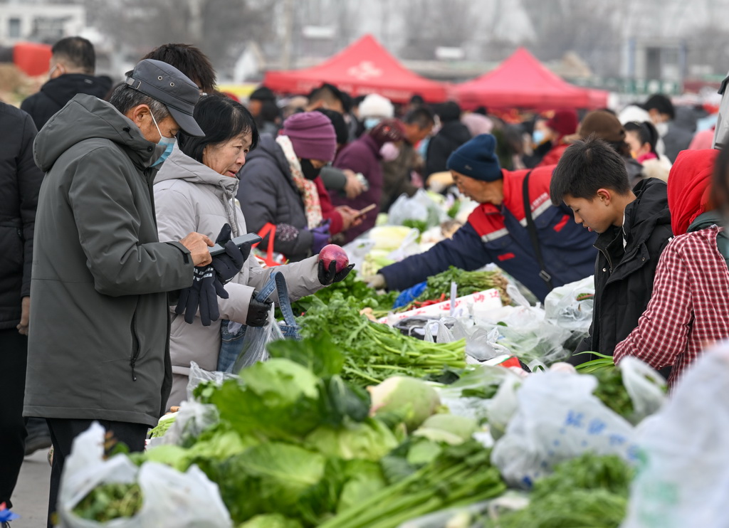 1月21日，人们在金贵集贸市场选购蔬菜。