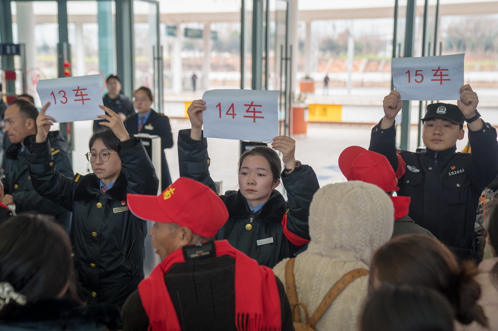 2月5日，铁路工作人员和民警引导务工专列乘客排队检票。