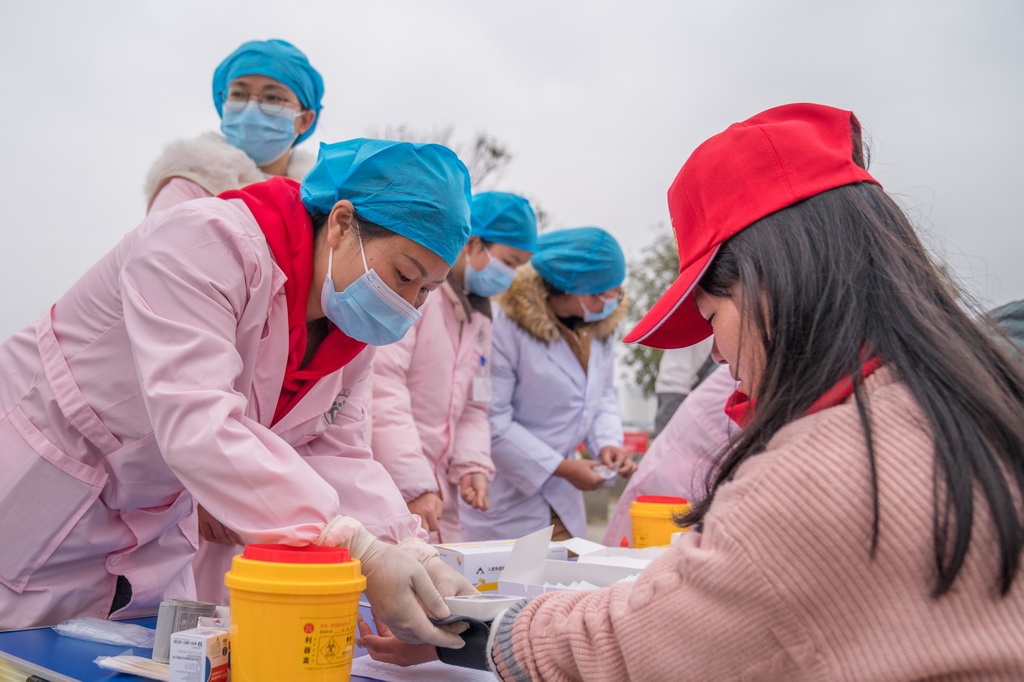 2月5日，医护人员在广南县站外为务工人员免费提供健康检查。