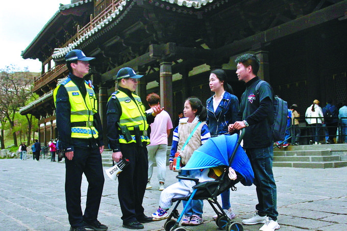 5月1日，大同市公安局云冈分局云冈景区派出所民警辅警在云冈石窟景区向游客宣讲安全知识。赵帅摄