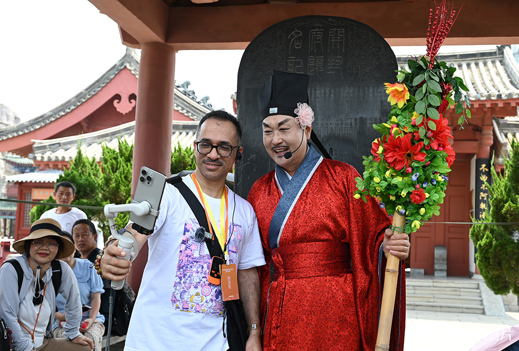 2025年6月27日，参加2025河南省文化旅游发展大会的境外行商代表在开封府景区和演员互动。人民网记者 王玉兴摄
