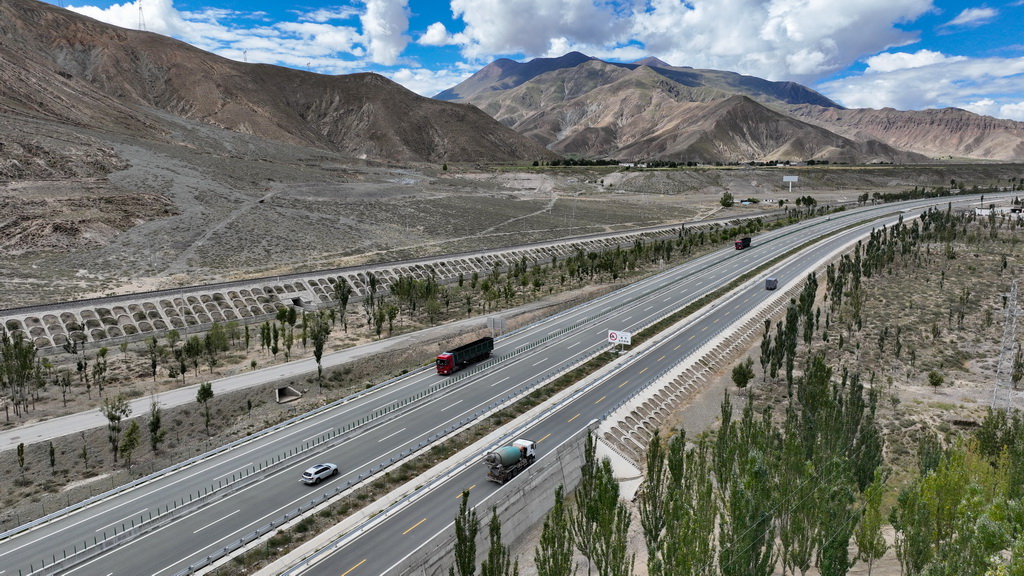 汽车行驶在拉萨至日喀则的高等级公路上（无人机照片，2024年9月11日摄）。