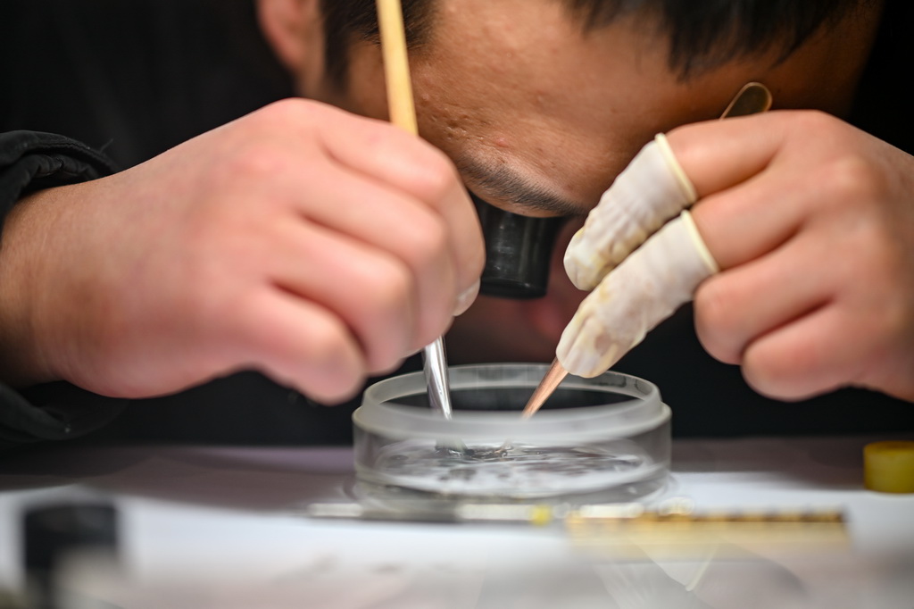 12月9日，商户在清理手表零件。新华社记者 张铖 摄