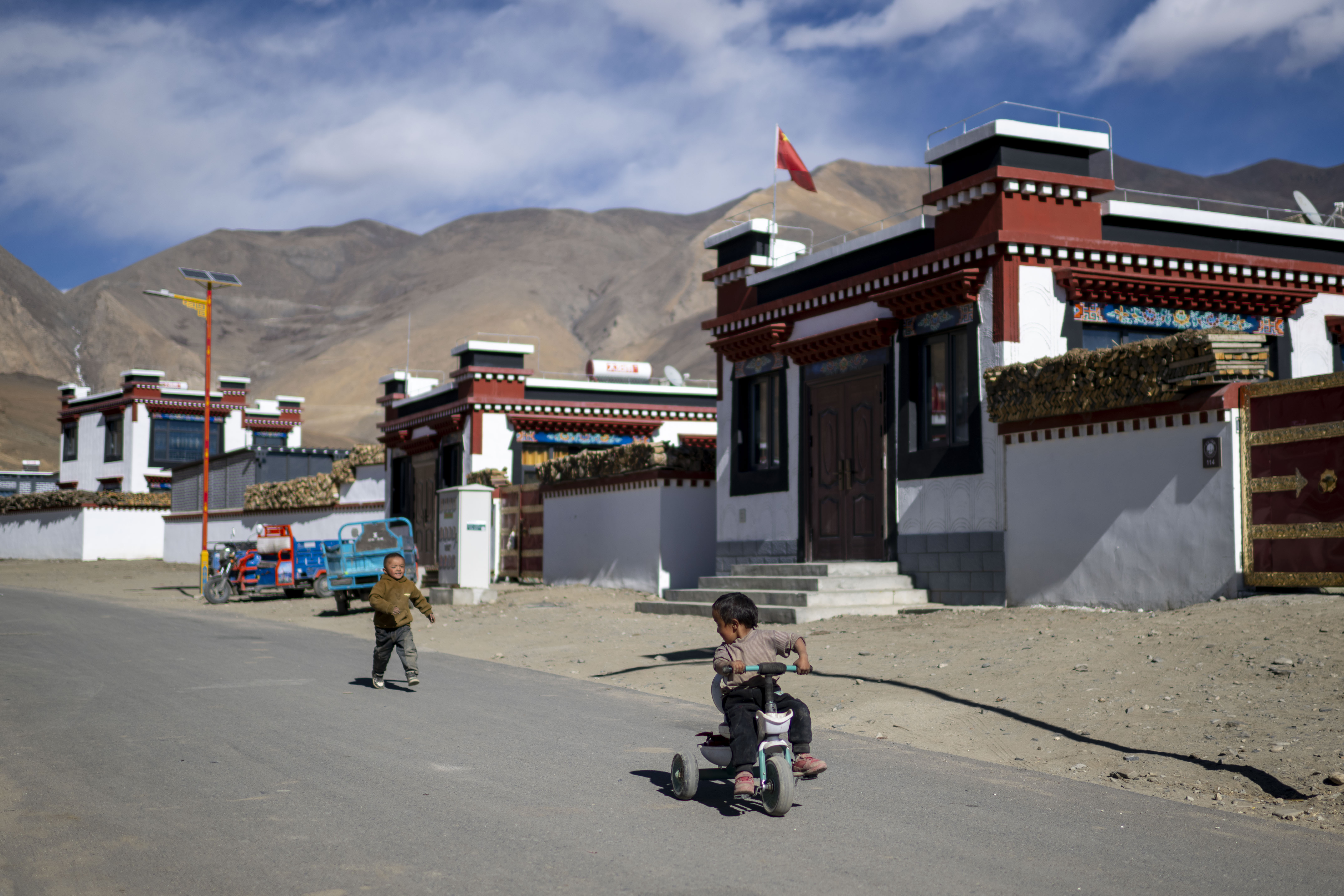 2025年12月11日，在西藏定日县长所乡森嘎村，小朋友们在整洁的村道上玩耍。人民网记者 翁奇羽摄