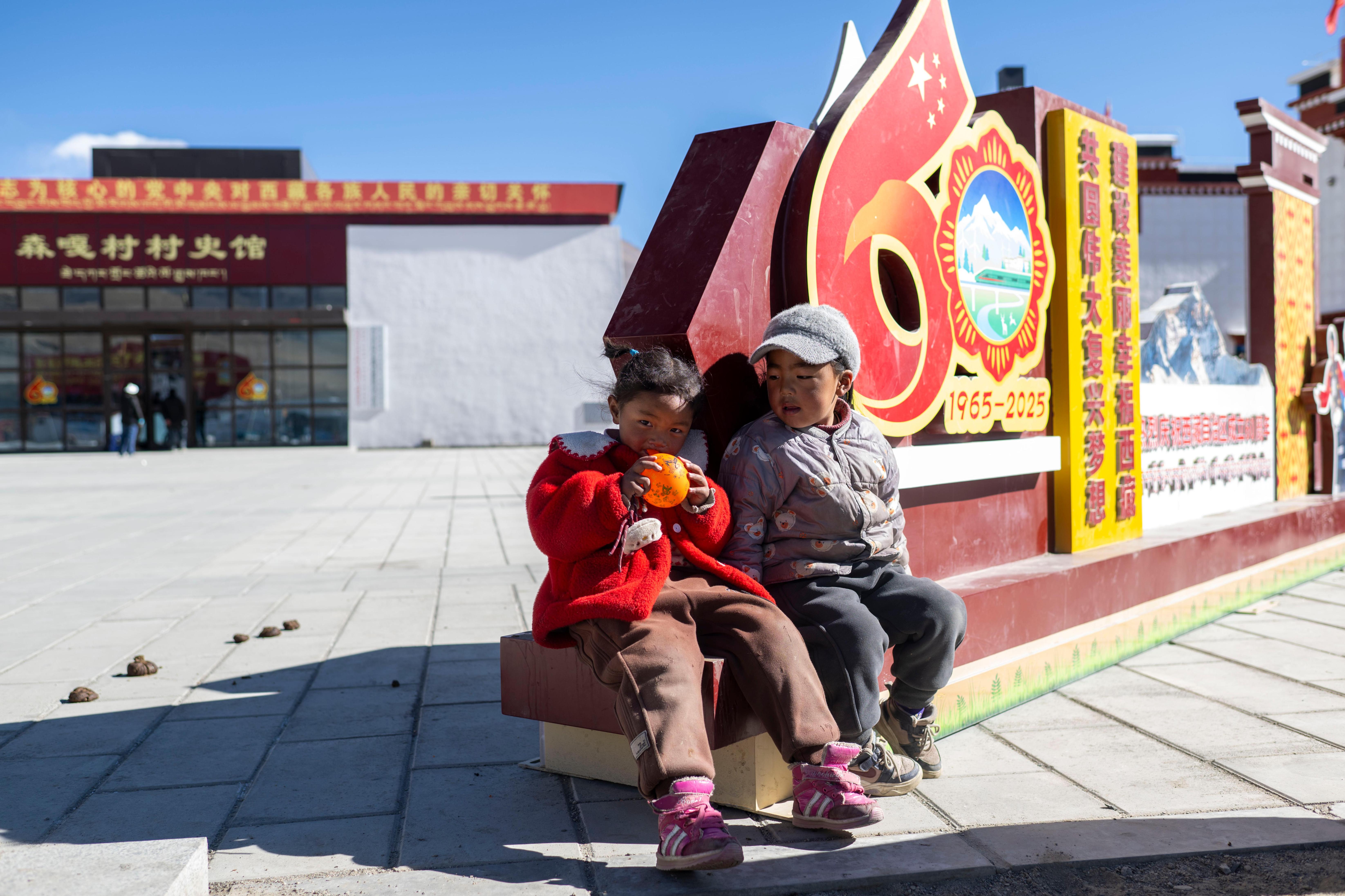 2025年12月11日，在西藏定日县长所乡森嘎村，小朋友们在村史馆前的广场上玩耍。人民网记者 翁奇羽摄