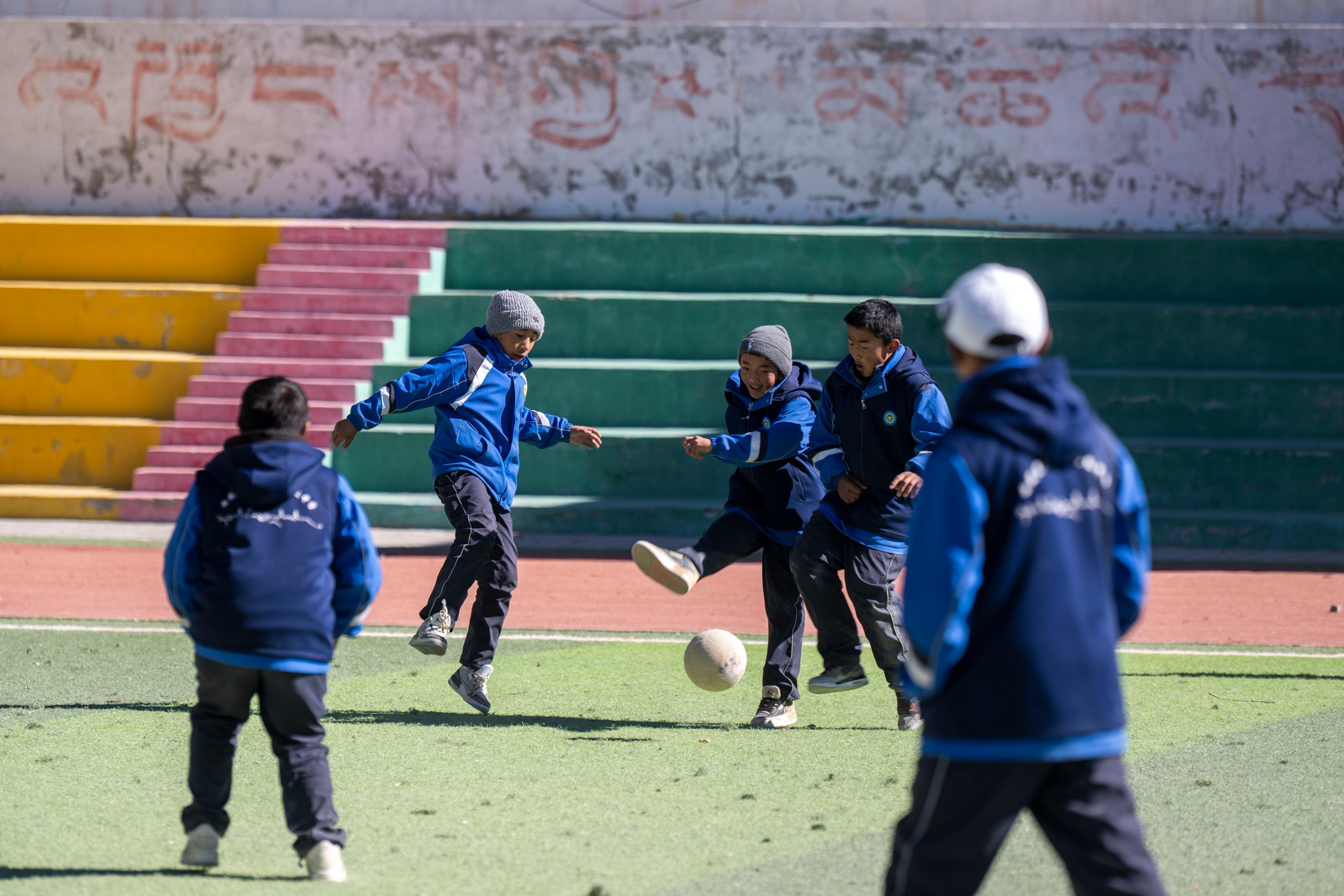 2025年12月12日，在西藏定日县第二初级中学，学生们课间在操场上踢球。人民网记者 翁奇羽摄