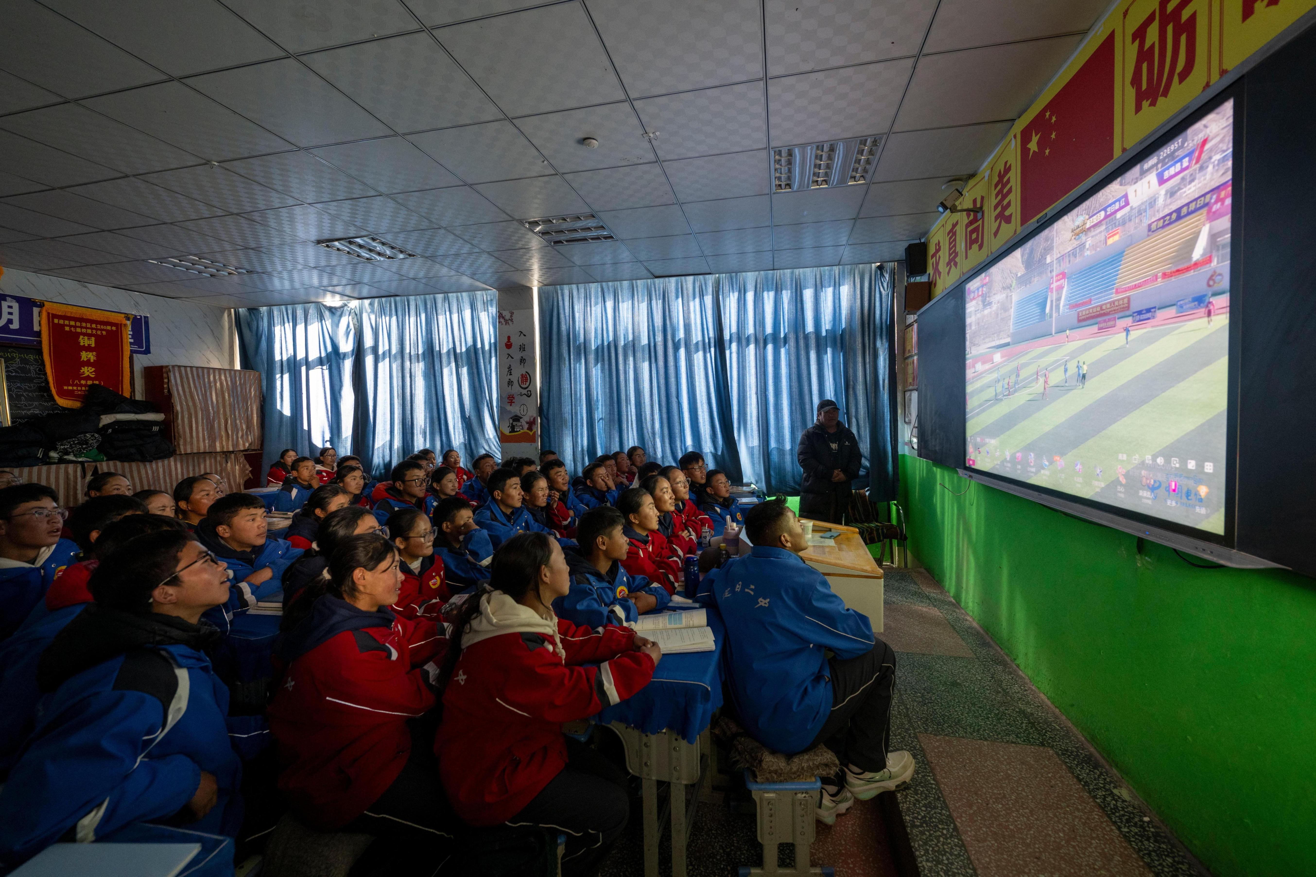 2025年12月12日，在西藏定日县第二初级中学，学生们正在观看日喀则市第十二届“体彩杯”足球赛定日县对阵吉隆县的比赛实况。人民网记者 翁奇羽摄