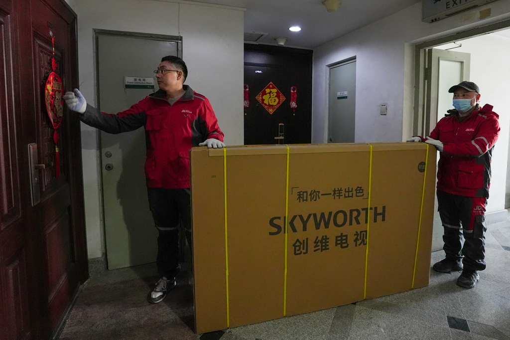 2月11日，在北京市朝阳区一个小区内，京东快递的快递员在配送消费者使用国家补贴购买的电视机。