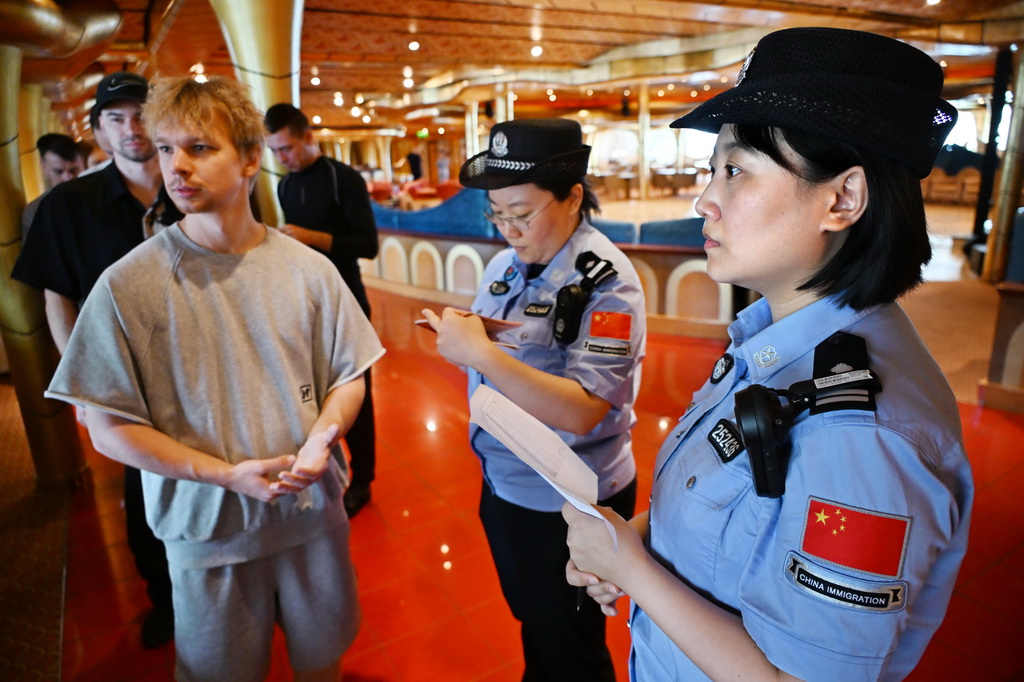 7月1日，青岛边检站民警在对“理想”号船员进行人证对照检查。