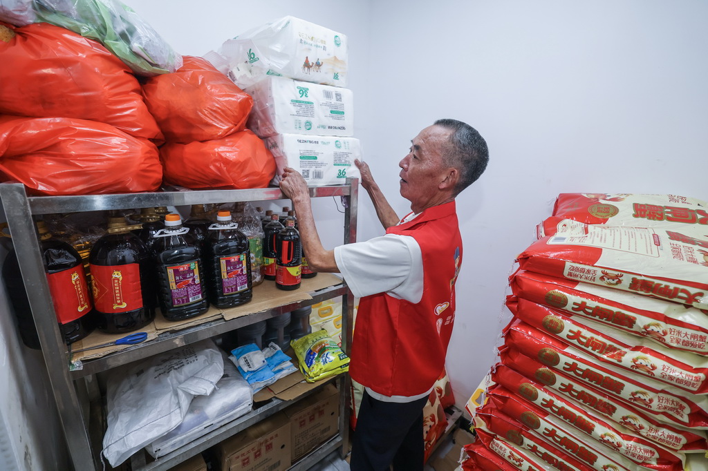 7月28日，荻浦村老年食堂的银发志愿者在老年食堂仓库清点捐赠的米面油盐等物资。