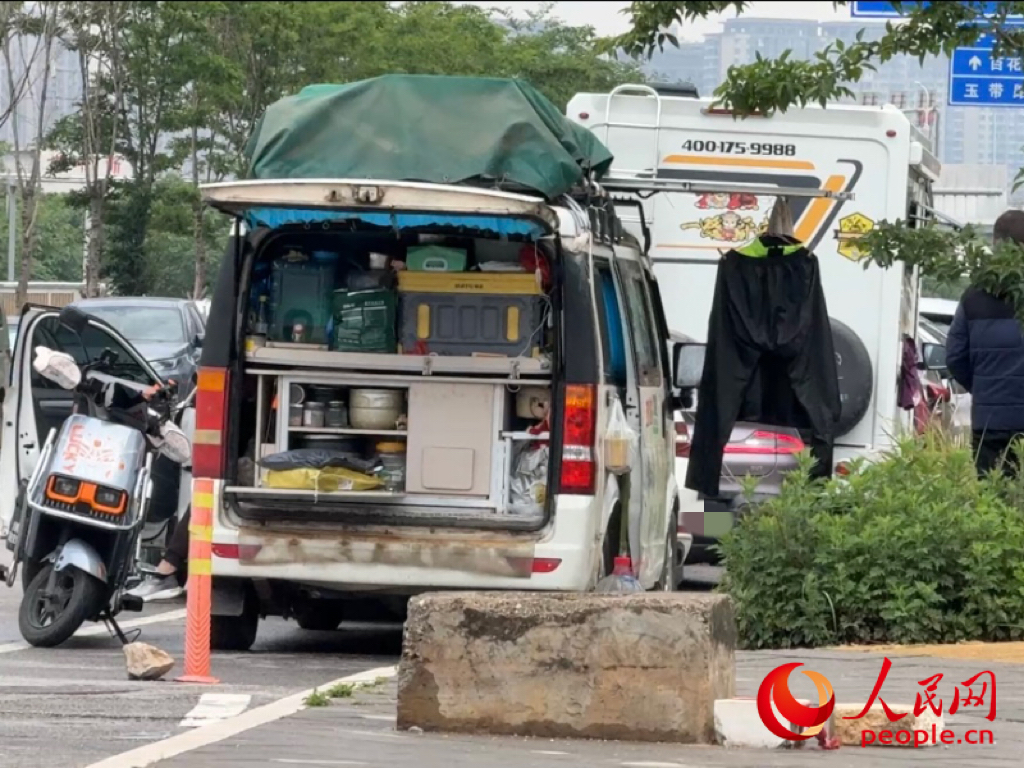 昆明市虾塘路，房车车主在路边晾晒衣物。人民网记者 蔡树菁摄
