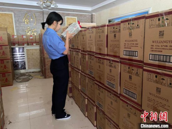 资料图为检察人员核对查获的假冒品牌白酒。　青海省人民检察院供图