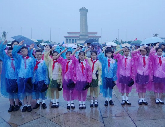 文县东童声齐唱团的孩子们面向冉冉升起的国旗敬队礼。