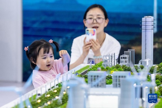 8月19日，在第七届中国―南亚博览会云南能投展区，一名家长带着孩子参观展览。