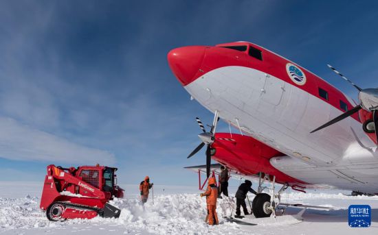 2月6日，雪鹰中国第40次南极考察队员为“雪鹰601”清理积雪。完成<strong>爱游戏最新首页登录</strong>新华社发（裴文悦摄）