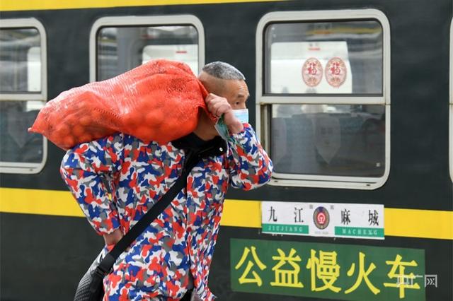 一名旅客扛着桔子准备乘坐“公益慢火车”（央广网发 胡国林摄）