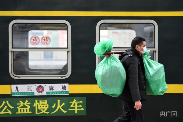 一名挑着年货的旅客准备乘坐6026次“公益慢火车”（央广网发 胡国林摄）