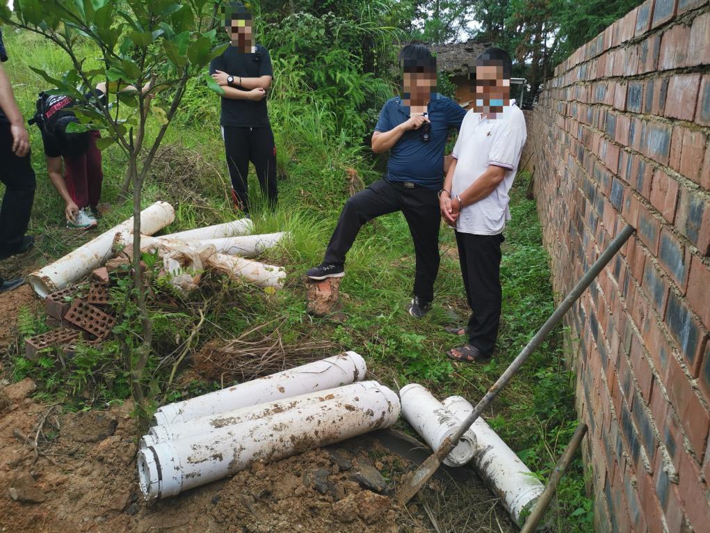 图为警方挖掘埋藏在地下的赃款。（警方供图）